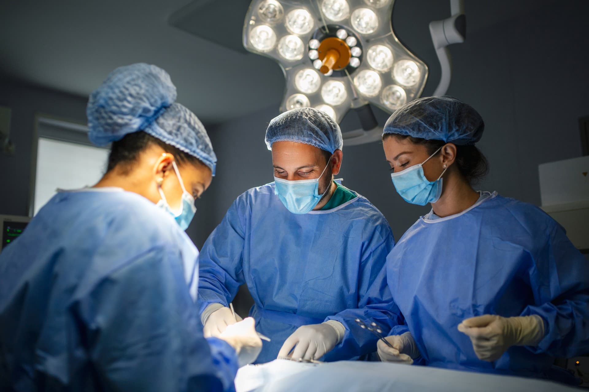 Surgical team performing matrix-assisted cartilage cell implantation