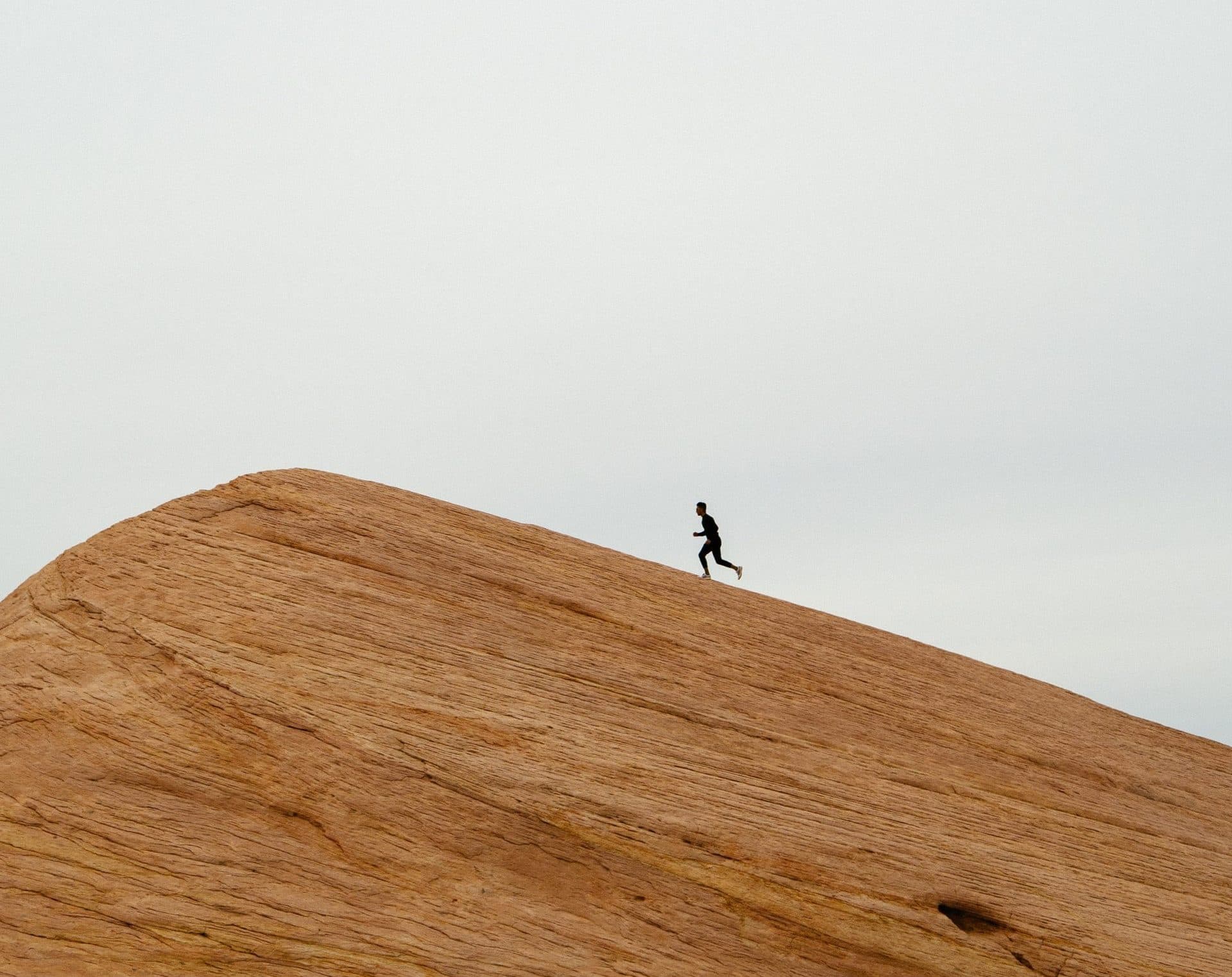 Runner climbing a red rock slope